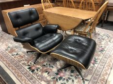 After Charles & Ray Eames : Model 670, a black leather plywood shell chair with stool, width 83 cm.