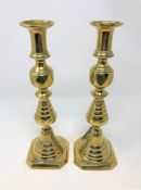 A pair of Victorian brass 'King of Diamonds' brass candlesticks with rise-motion bases,