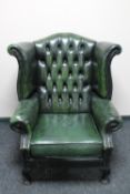 A green buttoned leather Chesterfield wingback armchair