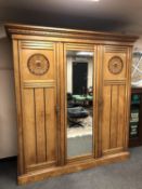 An Aesthetic triple door pitch pine wardrobe with central mirror panel,