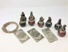 Eight eastern white metal mounted ornaments,