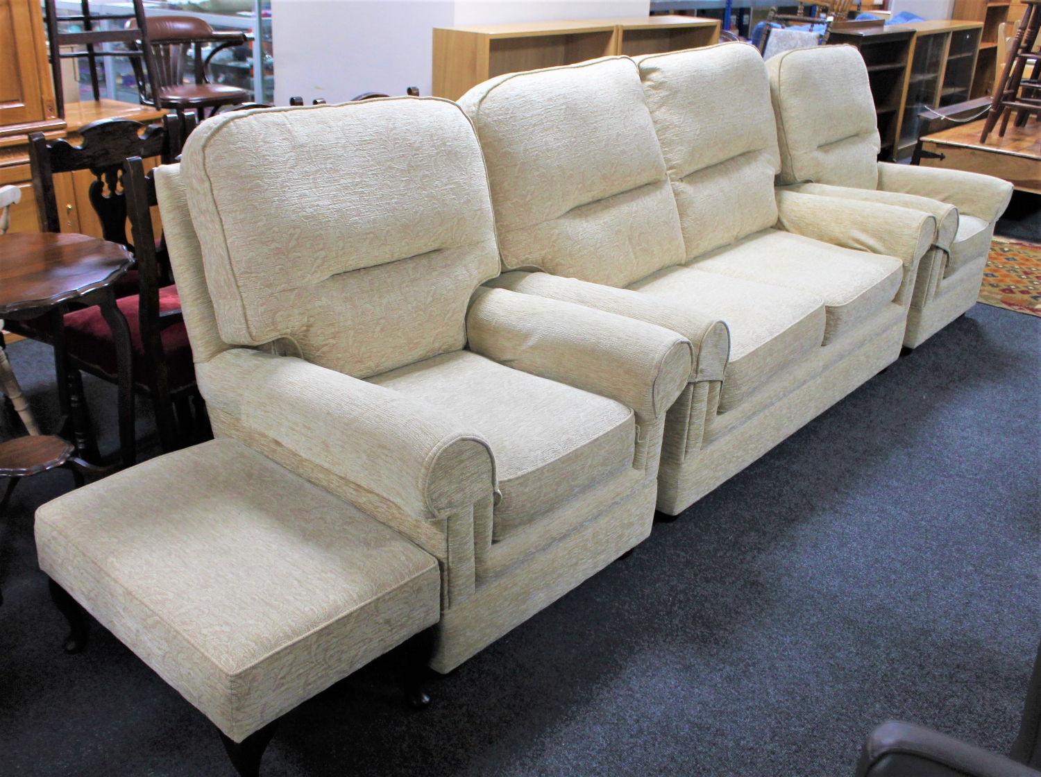 A contemporary three piece lounge suite in beige floral fabric plus footstool