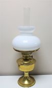 An antique brass Aladdin oil lamp with glass shade and chimney