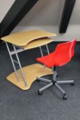 A computer desk and red plastic swivel chair