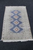 A fringed woollen rug of geometric design on cream ground