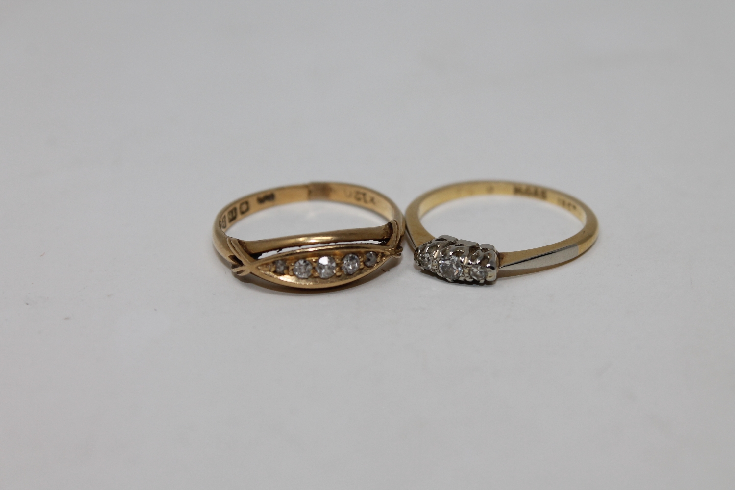 Two 18ct gold three stone and five stone diamond rings (2)