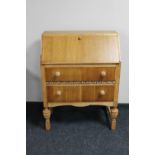 A mid 20th century oak writing bureau with pine handles