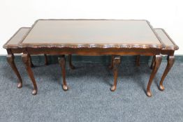 A mahogany glass topped coffee table fitted two tables beneath