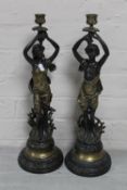 A pair of continental bronzed figural candlesticks
