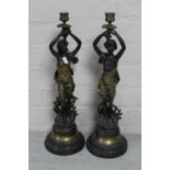 A pair of continental bronzed figural candlesticks