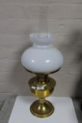 An antique brass Aladdin oil lamp with glass shade and chimney
