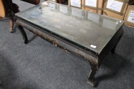 An oriental lacquered glass top coffee table depicting dragons