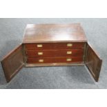 An antique mahogany double door cutlery cabinet fitted with three drawers and a small quantity of