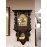 A continental oak cased wall clock with pendulum