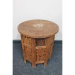 A carved Eastern hardwood folding table