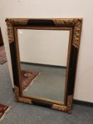A black and gilt framed mirror,