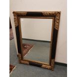 A black and gilt framed mirror,