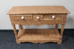 An antique pine two drawer side table in scumbled finish