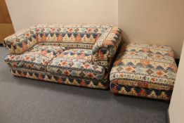 A contemporary two seater cloth settee in Aztec print and an oversized footstool