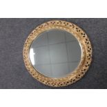 An ornate gilt oval framed mirror