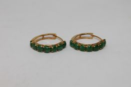 A pair of high carat gold mounted jade hoop earrings