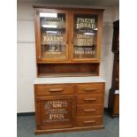 An early 20th century oak kitchen cabinet with later advertising decorations,