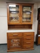 An early 20th century oak kitchen cabinet with later advertising decorations,