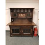 An oak Arts and Crafts sideboard with copper detail and inset panel,