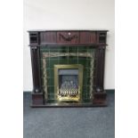 A contemporary Victorian style mahogany fire place with tiled back and brass fire insert