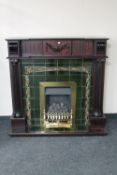 A contemporary Victorian style mahogany fire place with tiled back and brass fire insert