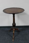 An antique mahogany wine table on three way pedestal