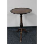 An antique mahogany wine table on three way pedestal