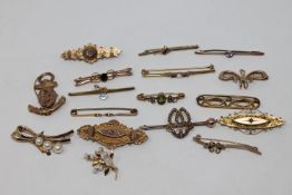 A good collection of seventeen gold brooches variously set with garnet, peridot, seed pearls,