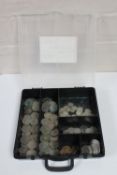 A plastic case containing a large quantity of pre-decimal silver three penny bits and other coins