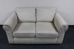 A two seater settee in beige fabric