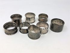 Eight assorted silver serviette rings.