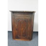 A George III inlaid oak corner cupboard