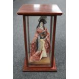 A Geisha figure in wooden display case