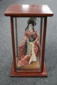 A Geisha figure in wooden display case