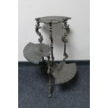An ornate metal three tier oriental style plant stand