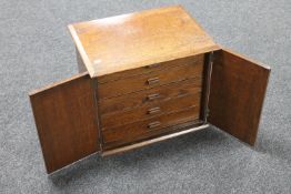 An Edwardian oak double door cabinet fitted five drawers internally