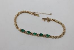 A 14ct gold emerald and diamond bracelet, length 17.