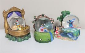 Three Disney snow globes : Jasmine, Mulan,