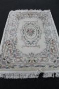 A fringed floral Chinese embossed rug on cream ground