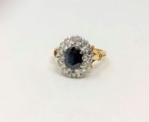 An 18ct gold diamond and sapphire cluster ring, the oval sapphire weighing approximately 1.