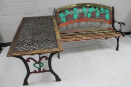 An iron and wood garden bench with grape leaf design together with a patio table