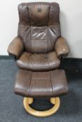 A brown leather Stressless adjustable reclining armchair with stool