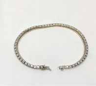 An 18ct white gold diamond line bracelet, set with sixty brilliant-cut stones,
