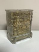A miniature glass lidded chest of drawers filled with gold leaf, height 11.