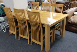 A contemporary oak extending dining table with leaf together with a set of six rail back chairs